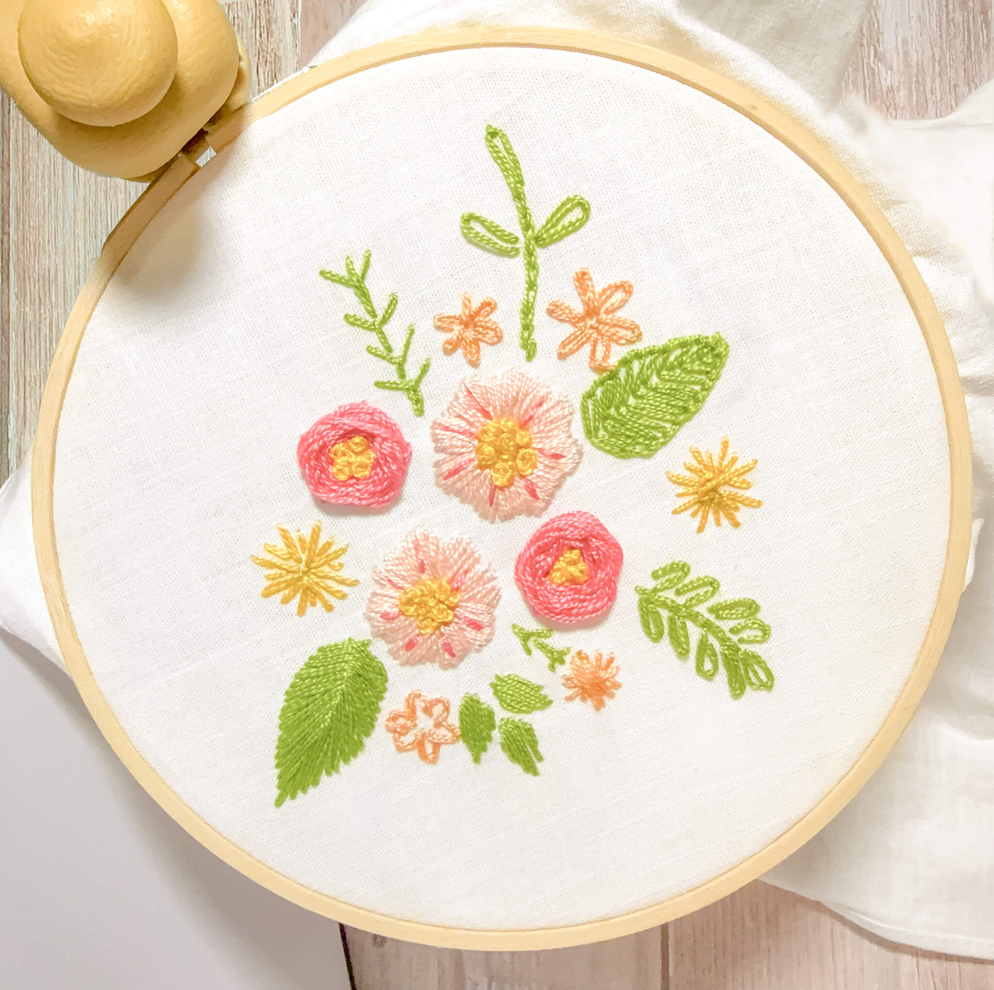 Embroidery hoop with floral design on a white background