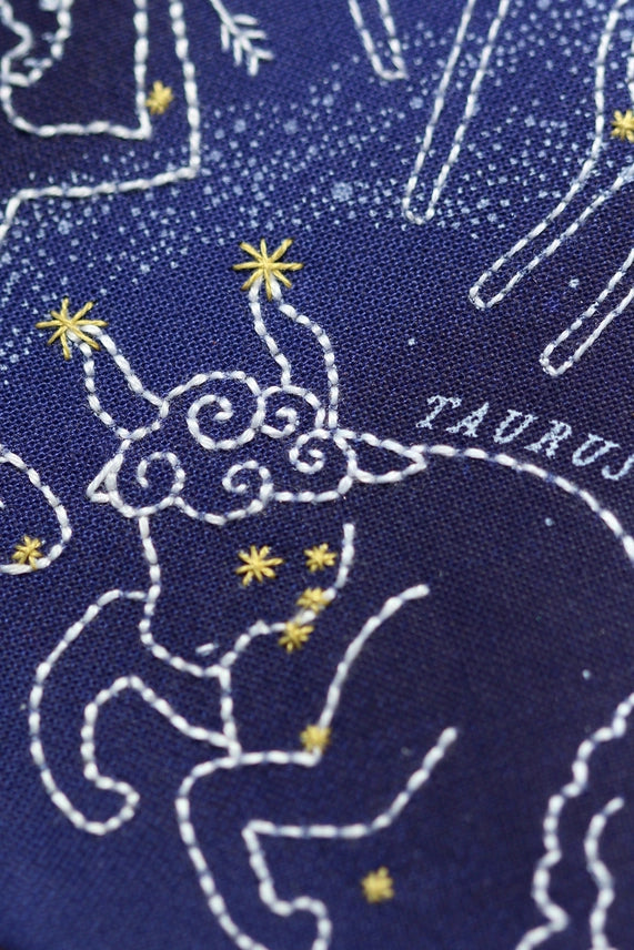 Embroidered design of Taurus constellation on a blue fabric background