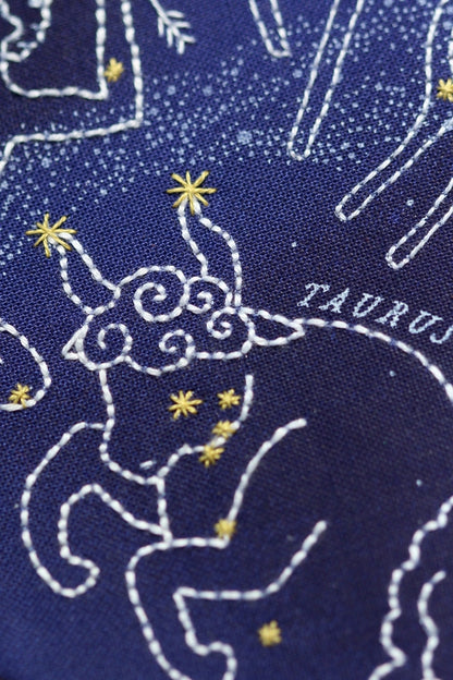 Embroidered design of Taurus constellation on a blue fabric background
